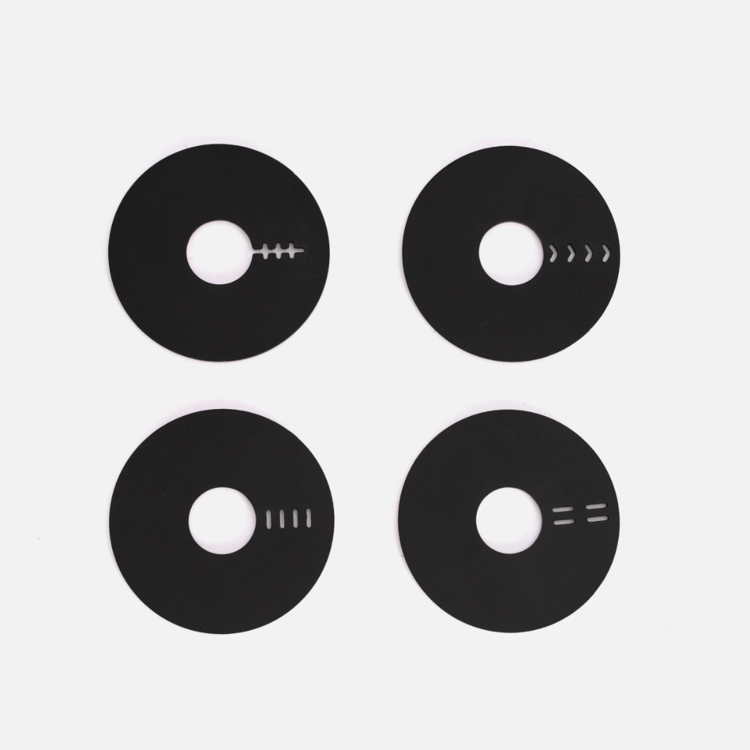 Four black coasters on a light gray background