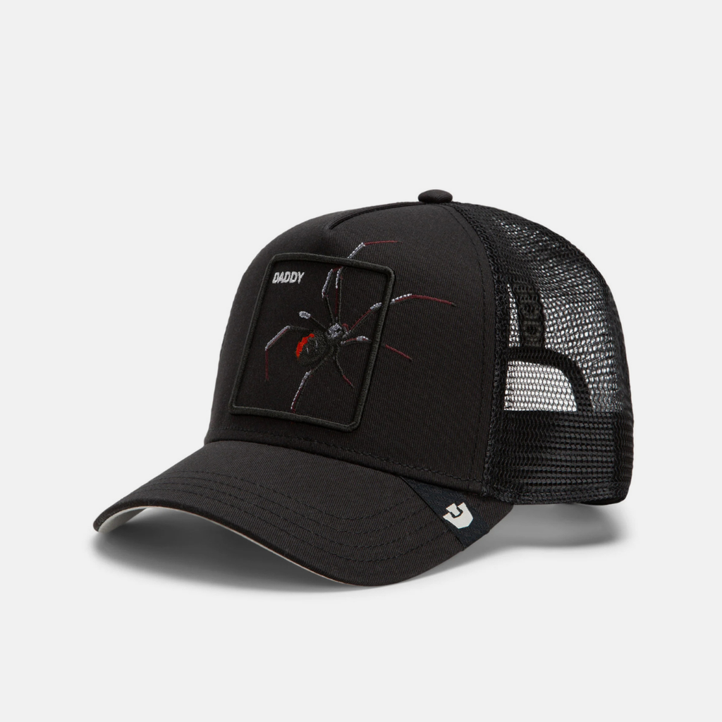 A black trucker-style cap with a curved brim, black mesh back, and a rectangular patch on the front featuring a spider graphic and the word 'SHADY'.
