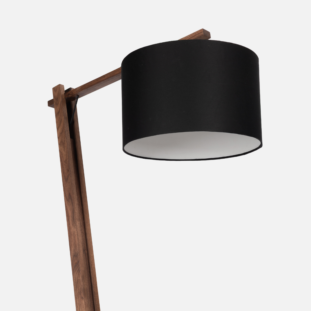 Floor lamp with a black shade and wooden arm on a white background